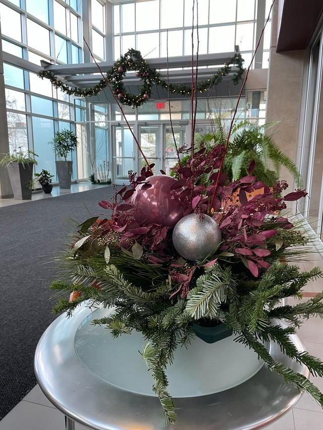 Festive arrangement with burgundy foliage and silver baubles in a lobby
