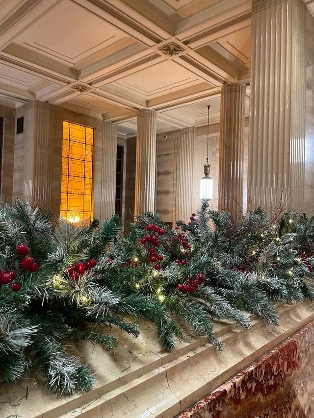 Flocked garland with red berries and lights along a marble ledge