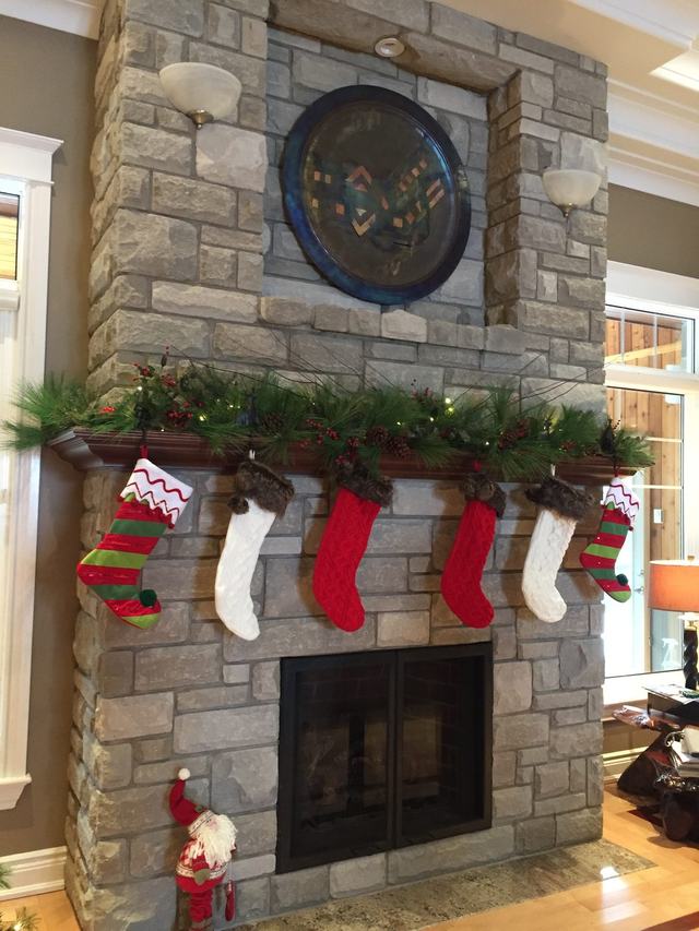 Garland and stockings on a stone fireplace mantel