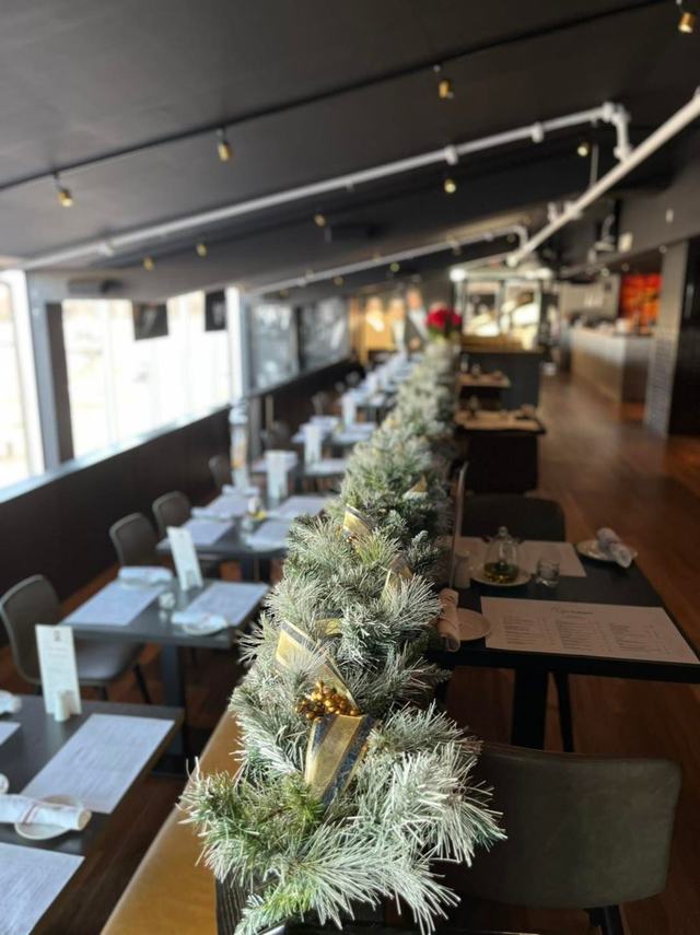 Flocked garland with gold ribbon along a restaurant bar