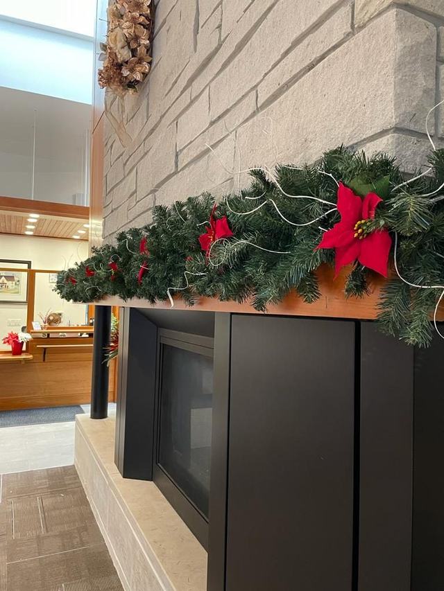 Garland with a red poinsettia on a fireplace mantel