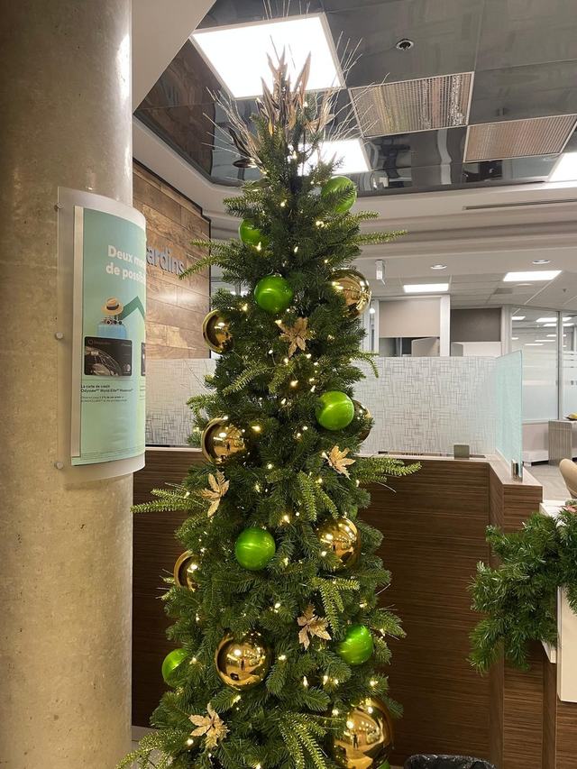 Pencil Christmas tree with lime green and gold baubles in an open office