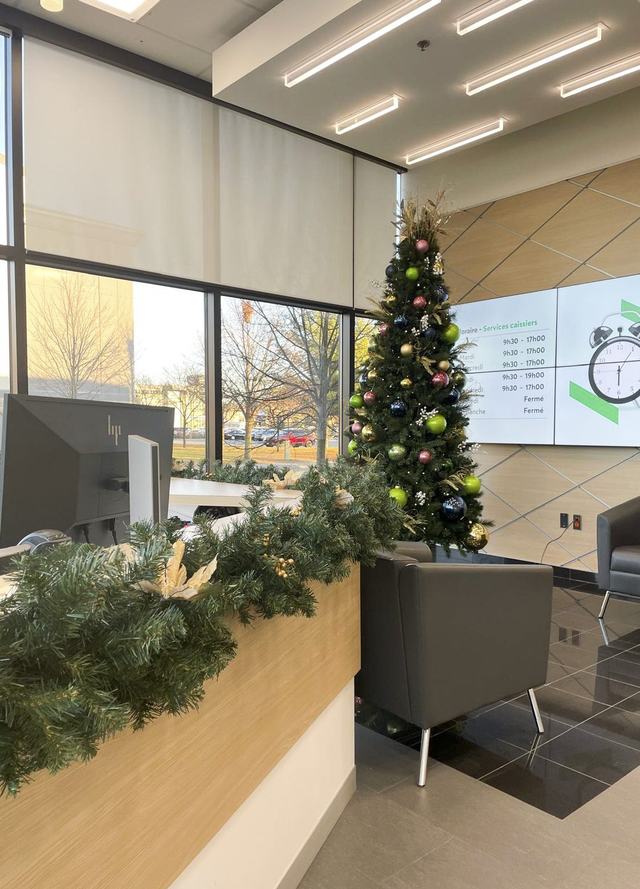 Christmas tree and green garland on a reception desk in a modern office