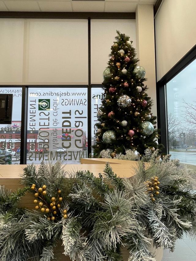 Decorated Christmas tree and flocked garland on a reception counter