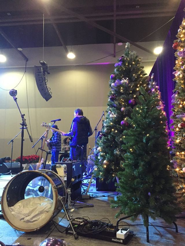 Decorated Christmas trees on stage at a live music event