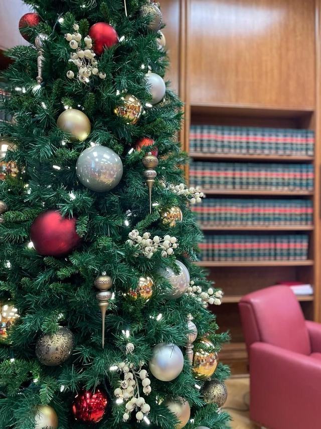 Close-up of a Christmas tree with red, silver and gold baubles and berries