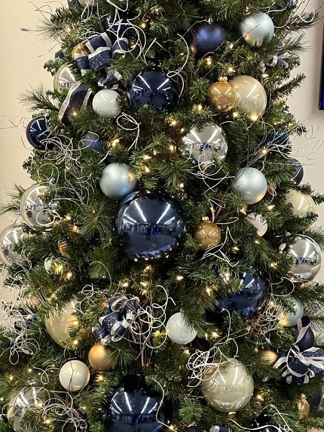 Close-up of navy, silver and gold Christmas baubles and ribbon