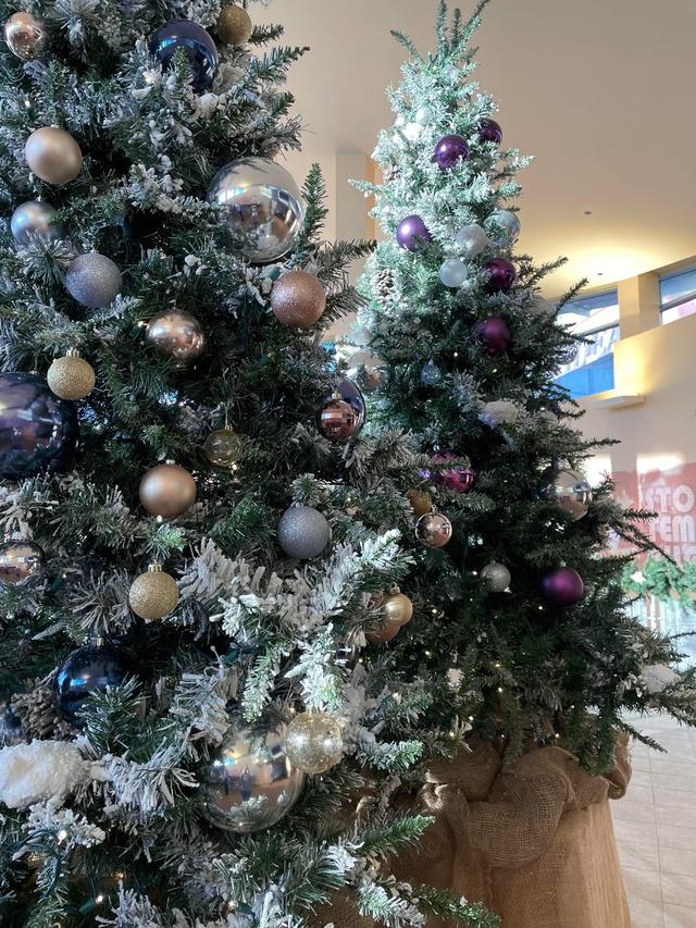 Flocked Christmas trees with silver, bronze and purple baubles