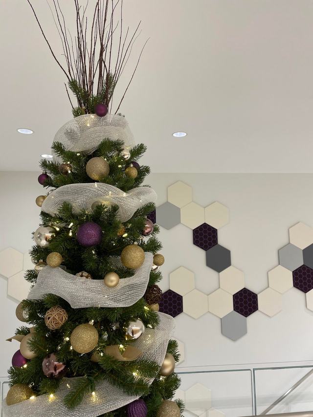 Close-up of a Christmas tree with cream mesh ribbon and gold baubles