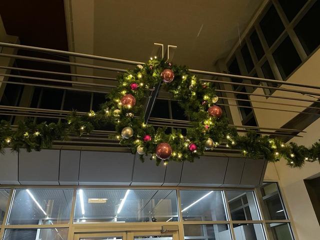 Christmas wreath and lit garland above an entrance